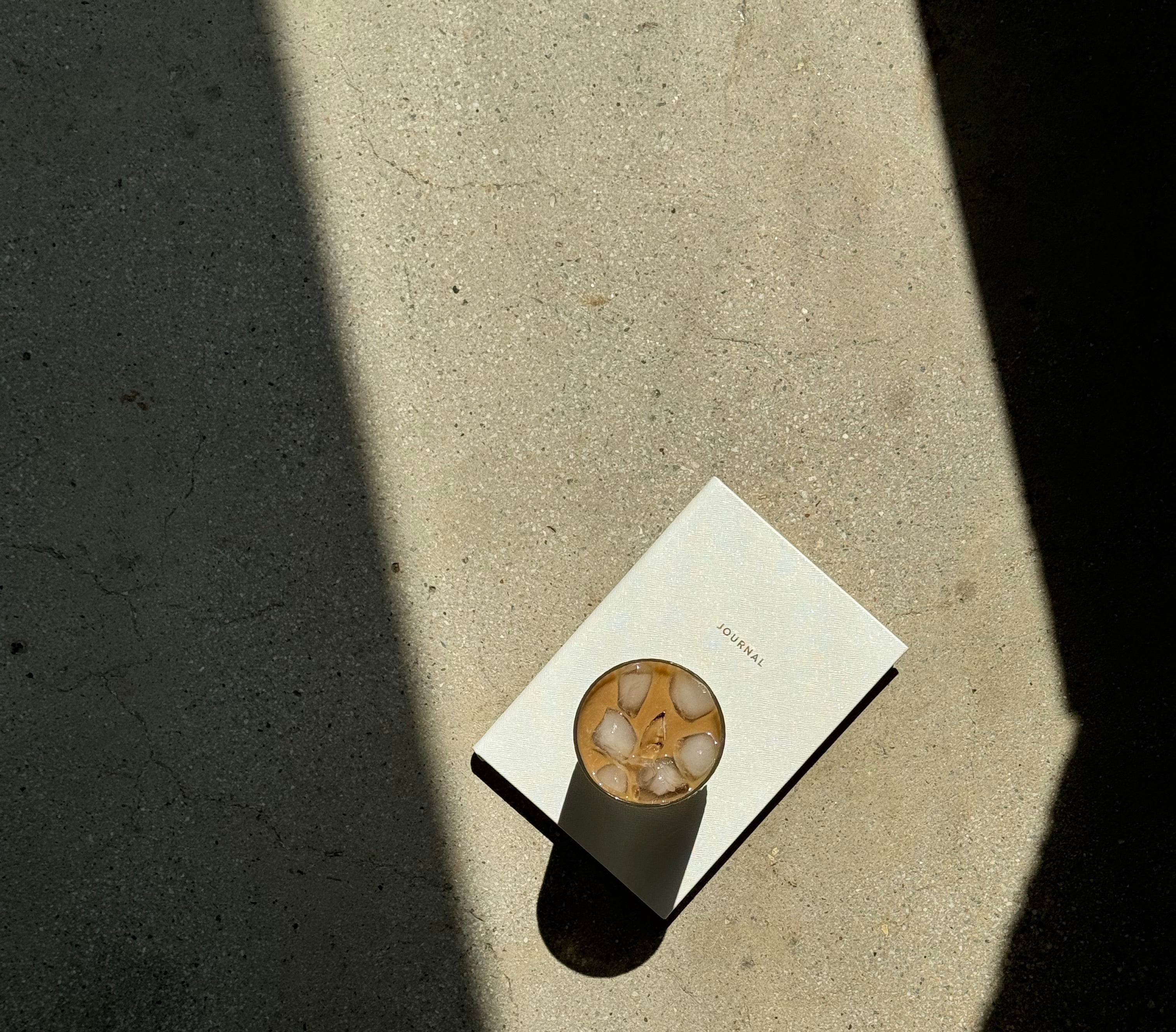 Person's feet on a sidewalk with a coffee cup on a napkin