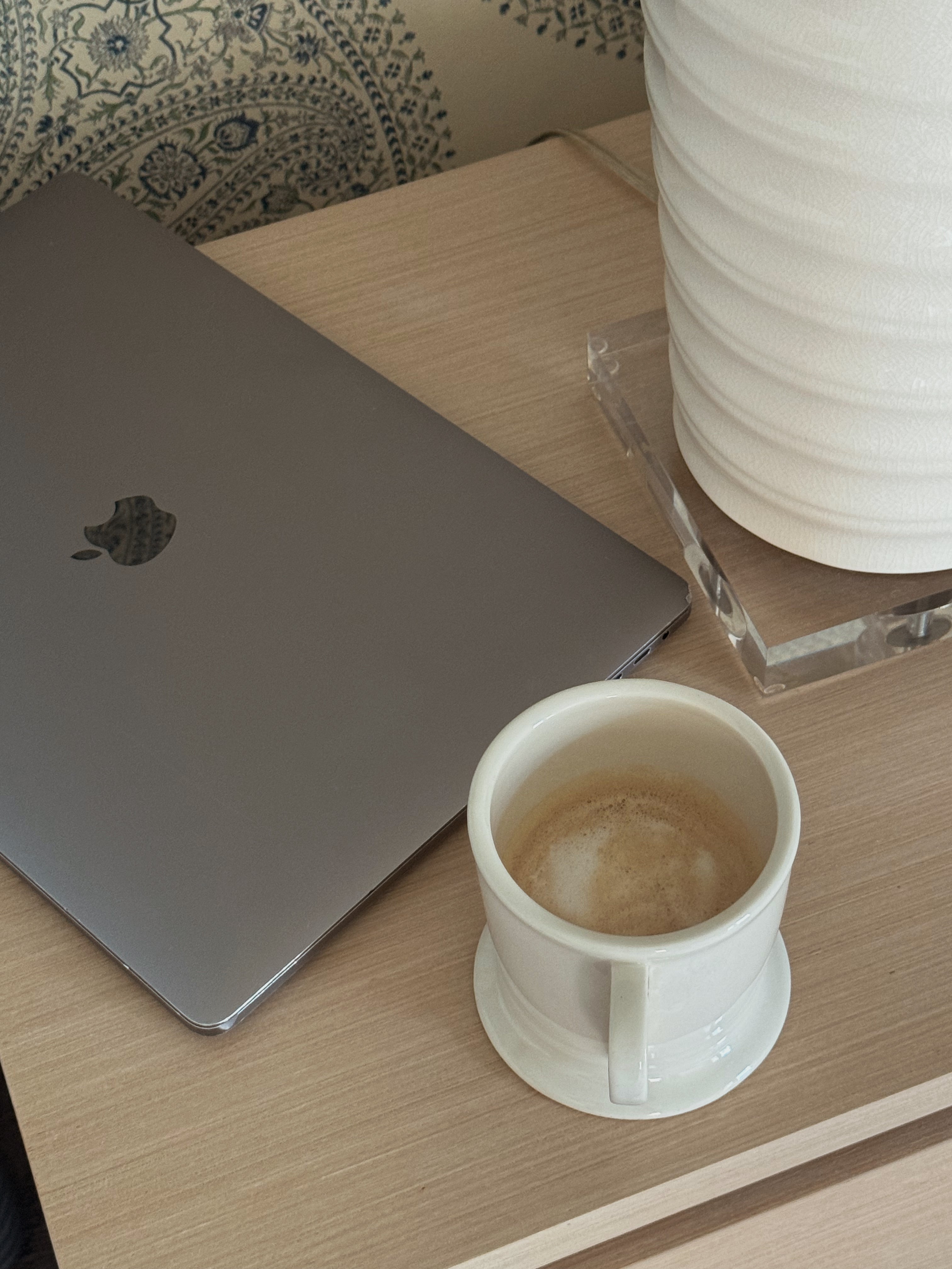 Laptop on a desk with a coffee cup and glass of water