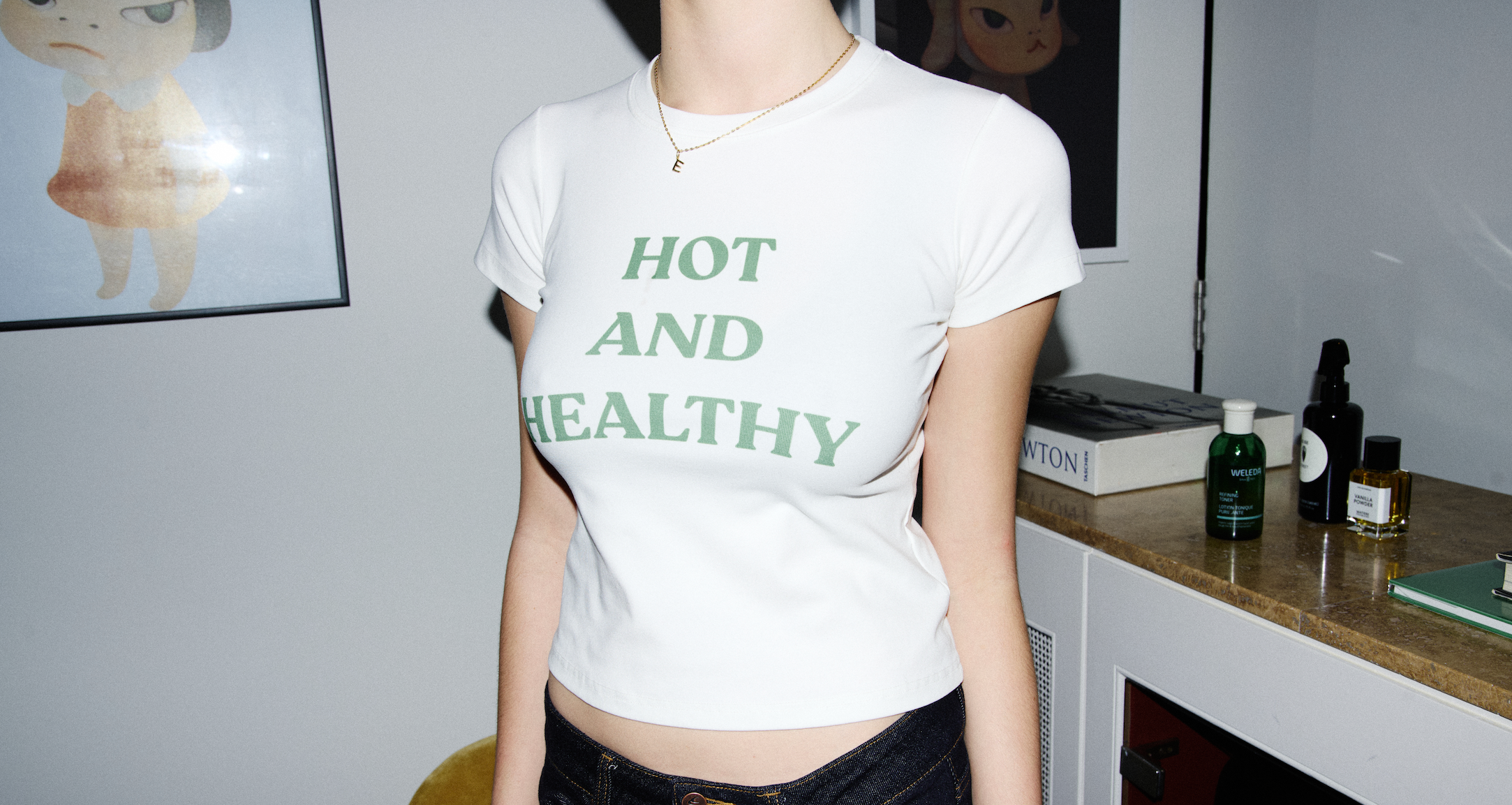 Person wearing a white t-shirt with 'HOT AND HEALTHY' text in a room.